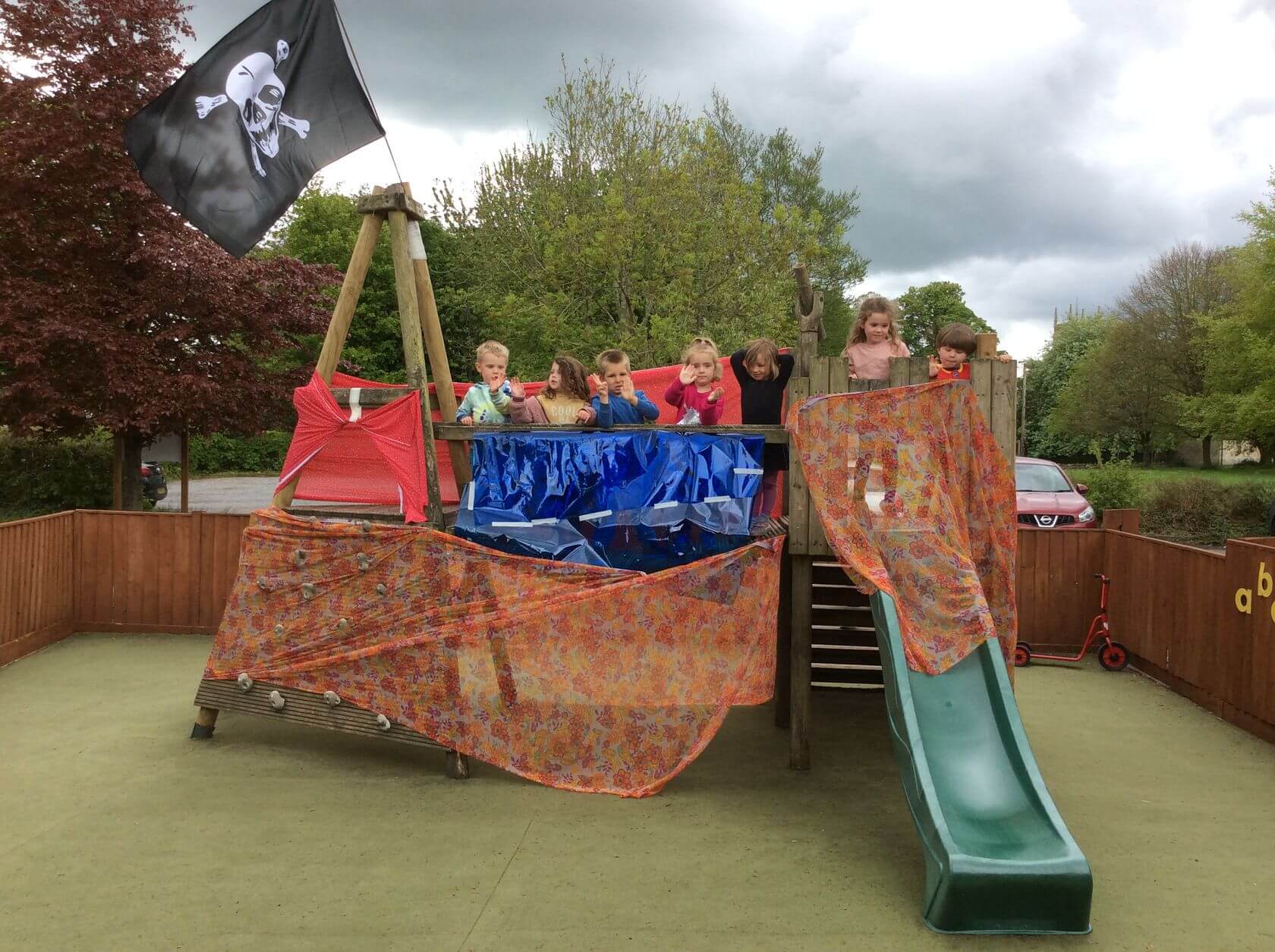 Marshfield Pre-School children playing within a makeshift pirate ship
